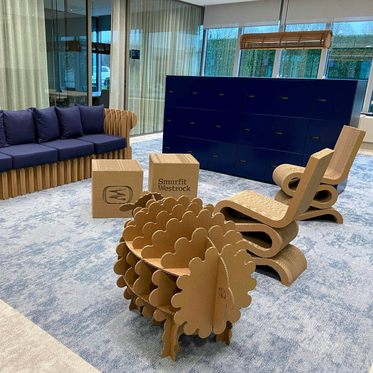Kartonnen kantoorinrichting, golfstoelen, boekenrek van een schaap, tafels, lampen een een loungebank