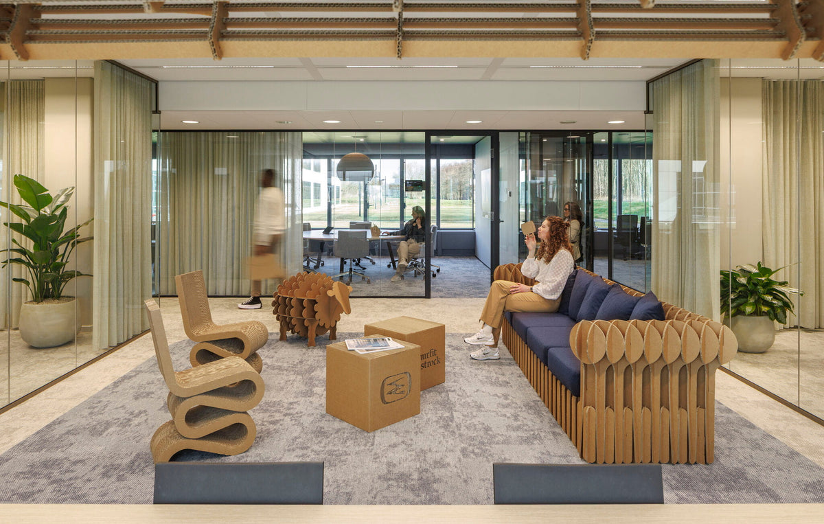 Kartonnen kantoorinrichting, golfstoelen, boekenrek van een schaap, tafels, lampen een een loungebank